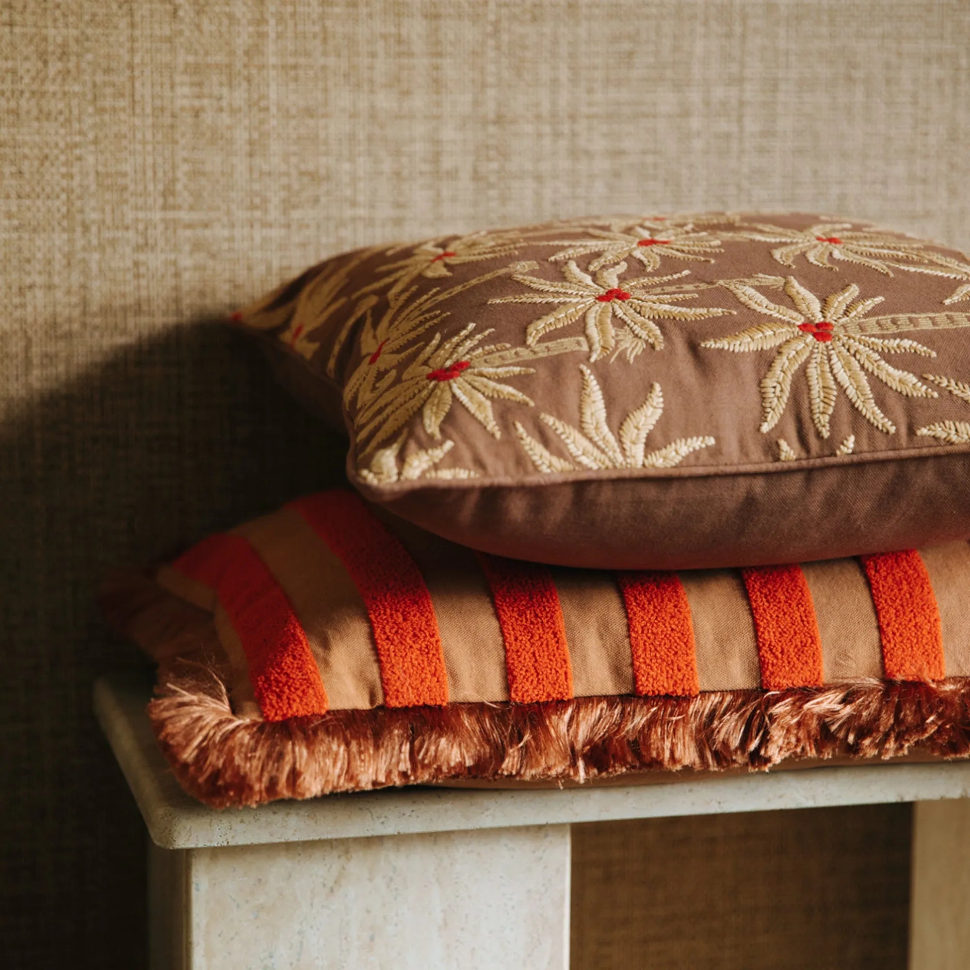 A cozy reading nook featuring a Laura Cushion in a warm, inviting space