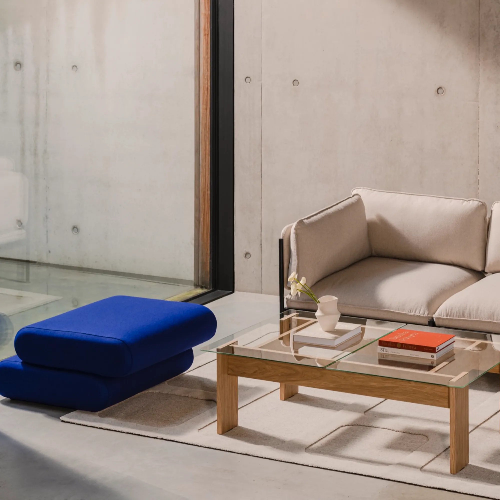 Taso Pouf in classic black fabric with sleek and minimalist design