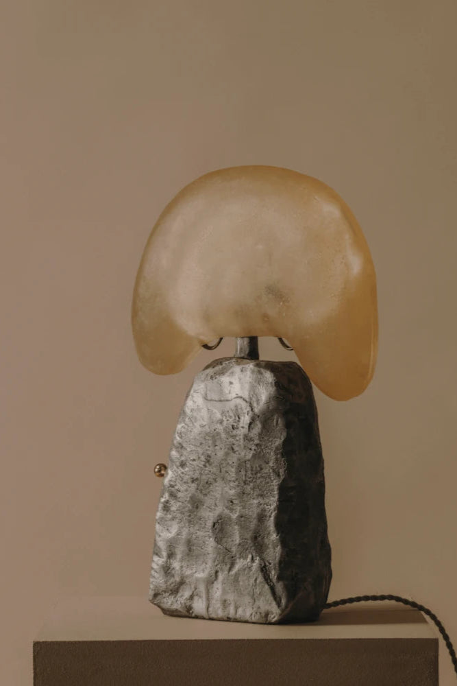 The Cashew Lamp, a sleek and modern lighting fixture, illuminates a room with warm, soft light