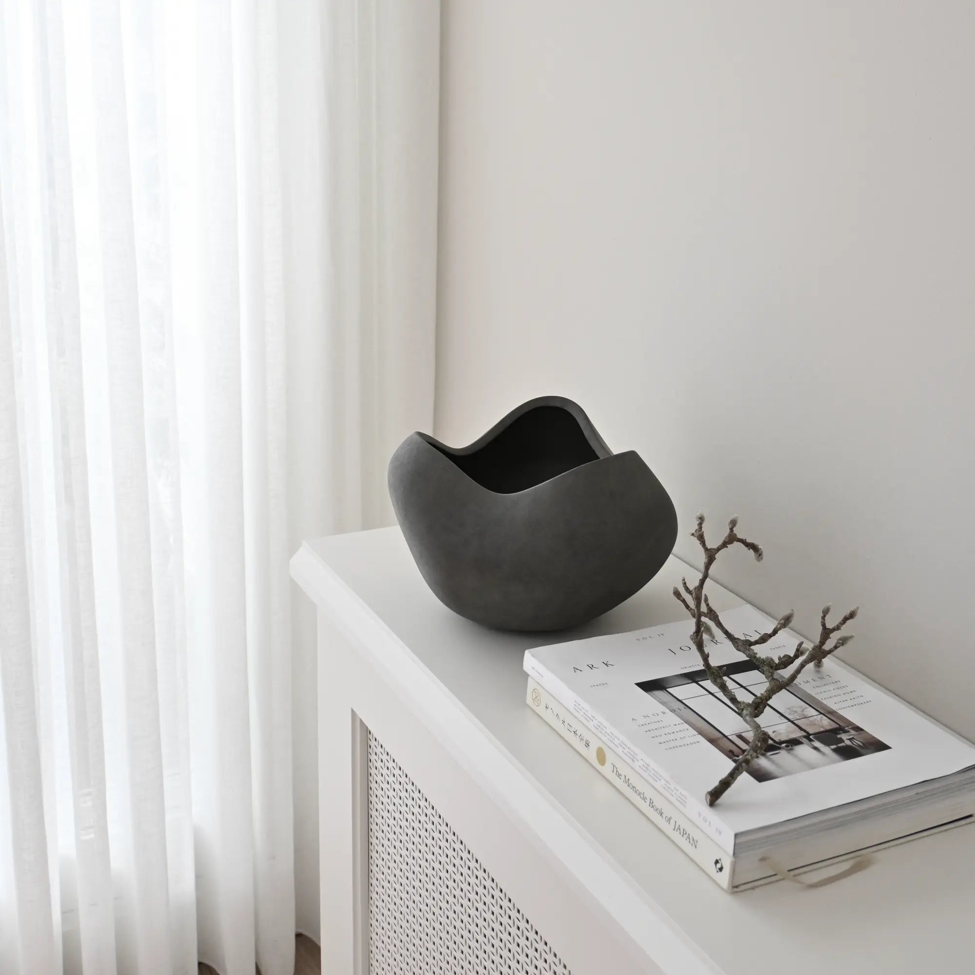 Large white ceramic curve bowl with smooth, rounded edges and a spacious interior for serving or display