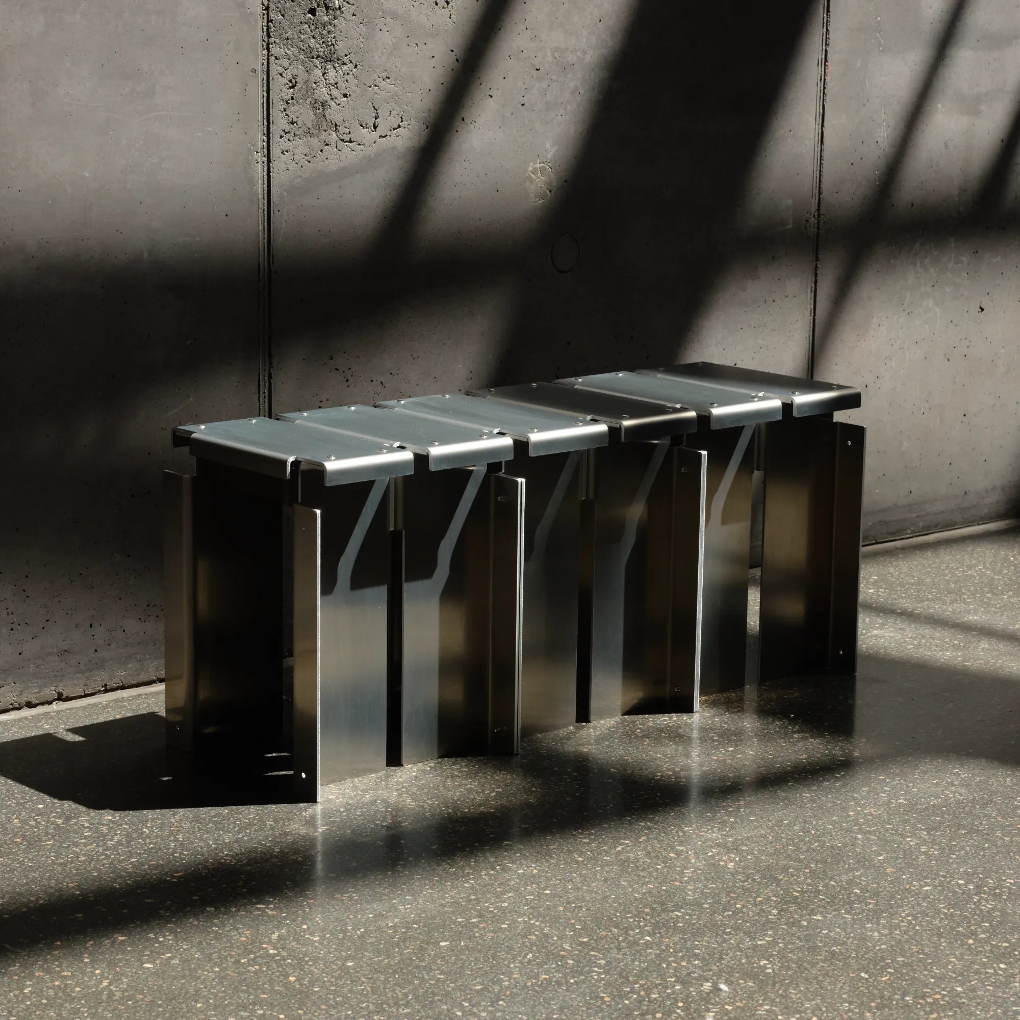  Segment Stool displayed in a minimalist workspace, highlighting its sleek design