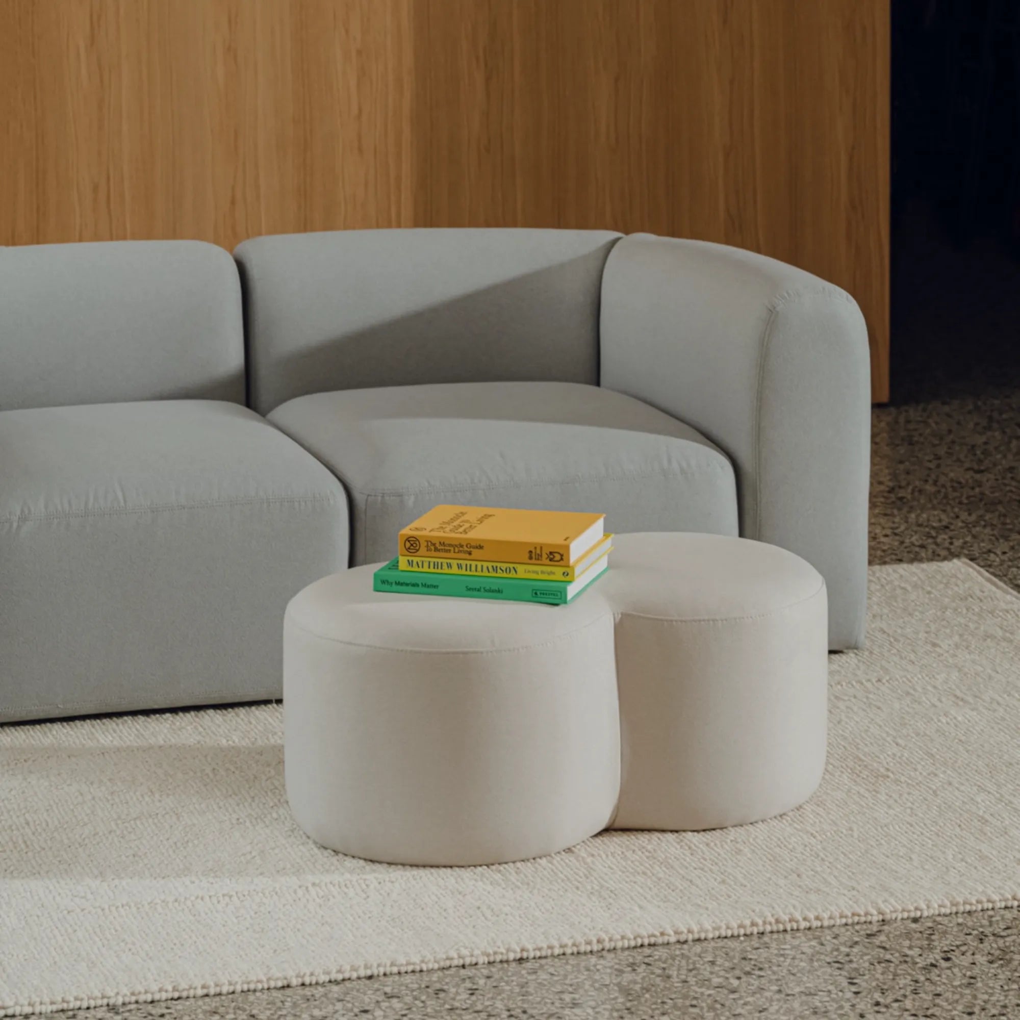 Round Umbo Pouf upholstered in gray fabric with button tufting